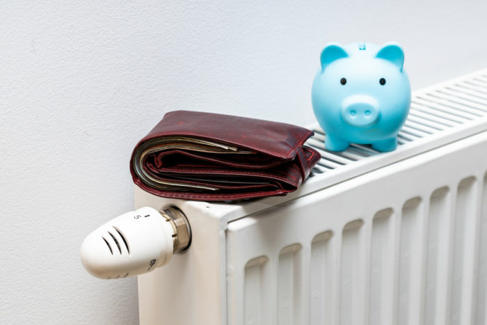 piggy bank and wallet on top of a radiator. The wallet represents Winter Fuel Payment