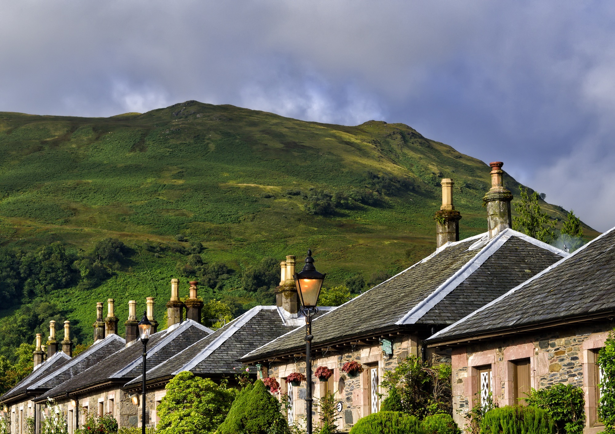 A row of traditional houses that will need a retrofit. Behind them is a tall green hill