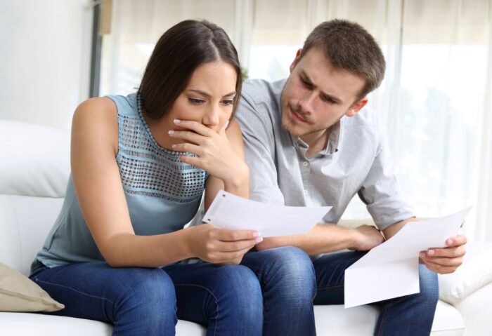 A man and woman looking at a form to register their solar panel system.