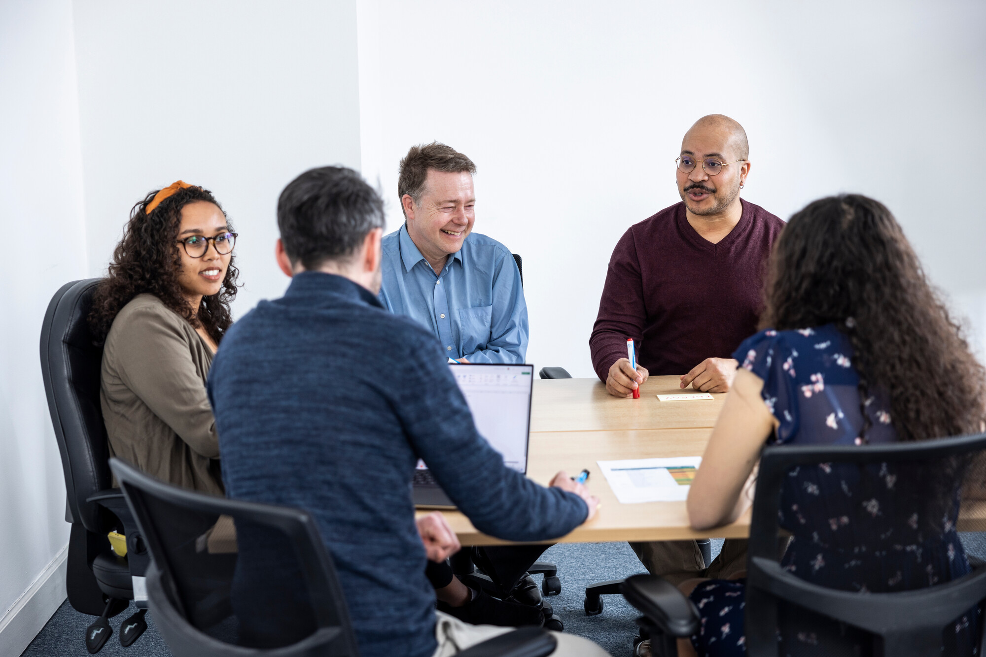 Colleagues gather around a table to discuss their work.