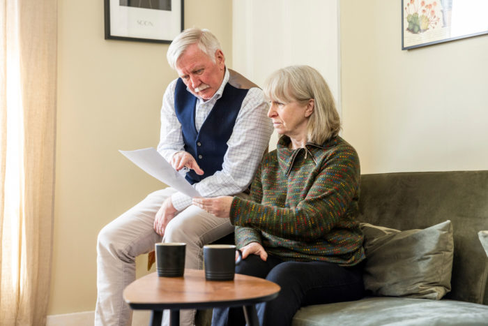 An elderly couple reading their energy bill.