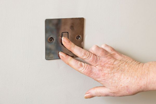 close up of hand turning off light switch