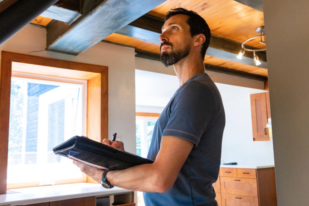 Retrofit assessor with clipboard and pen inside a home