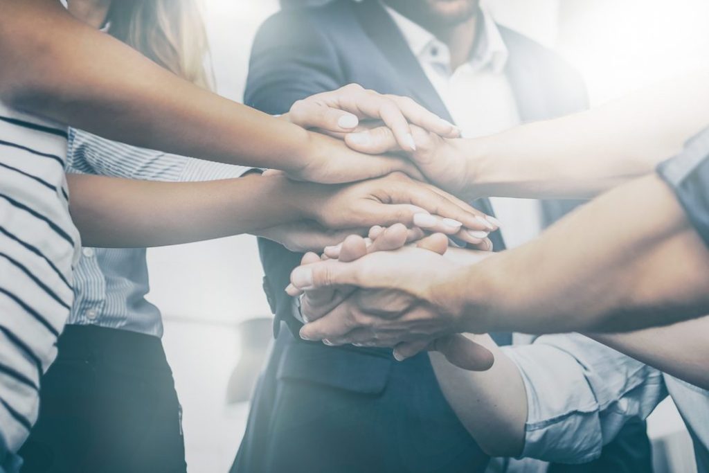 close up of several people's hands placed on top of each other
