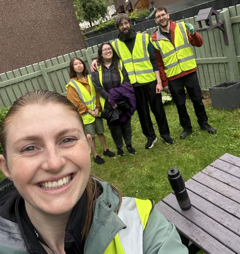Volunteers in high viz standing in Collydean Community centre garden