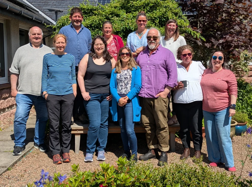 A group of people standing in a garden outside Coigach Community Hall 
